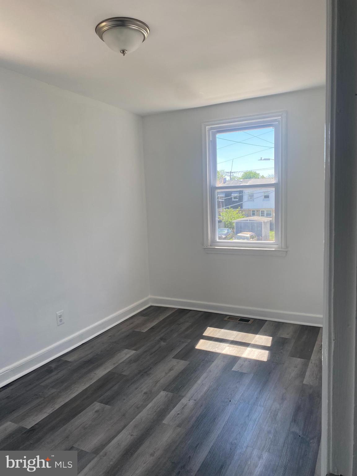3643 Greenvale Road Baltimore, MD 21229 - Photo 12 of 23 an empty room with wooden floor and windows