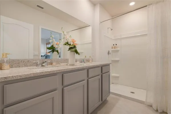 a bathroom with a granite countertop sink and a mirror