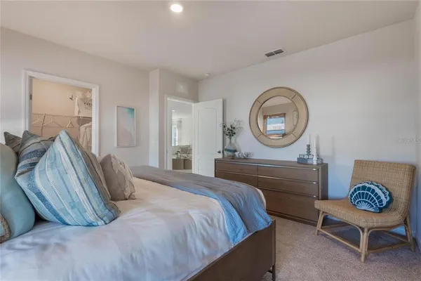 a bedroom with a bed and a lamp on dresser