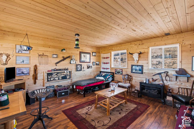 1054 East Jakes Pl Road Fremont, UT 84747 - Photo 16 of 18 Rec room featuring a wood stove, wood ceiling, wood walls, and hardwood / wood-style floors