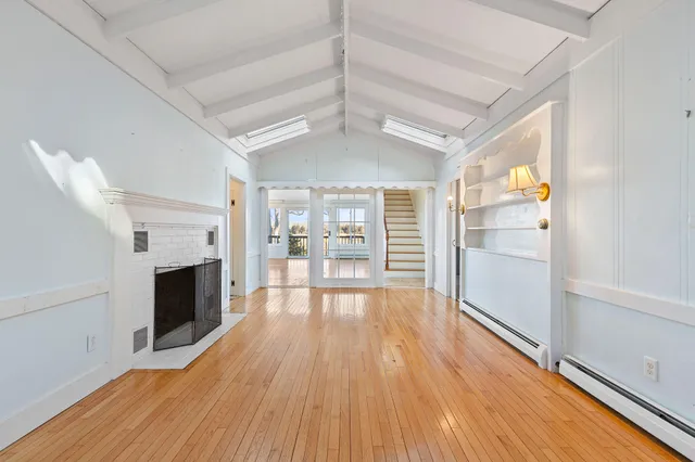a view of empty room with wooden floor and fireplace