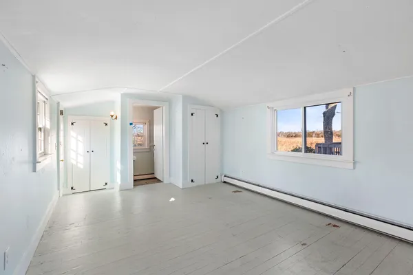 a view of a hallway with a window and a bathroom