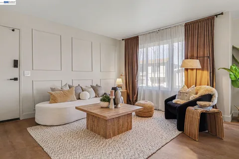 a living room with furniture a mirror and white walls