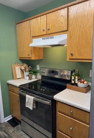 a kitchen with wooden cabinets and a stove top oven