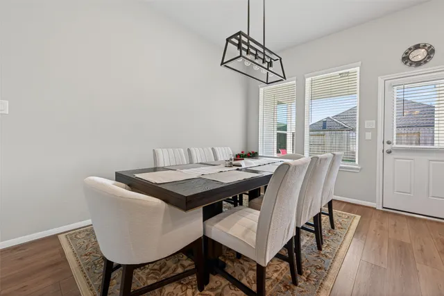 a kitchen with stainless steel appliances granite countertop a sink a stove a refrigerator and island with wooden floor