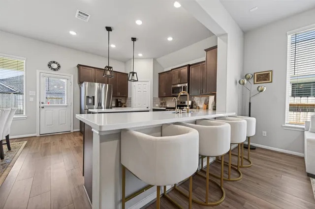 a living room with kitchen island furniture and a view of kitchen