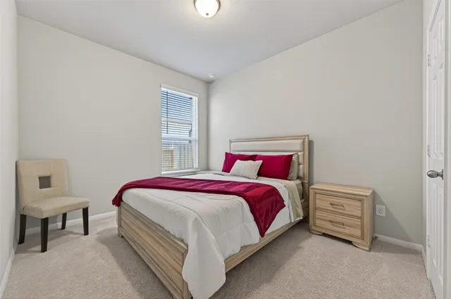 a spacious bedroom with a bed a table and chair