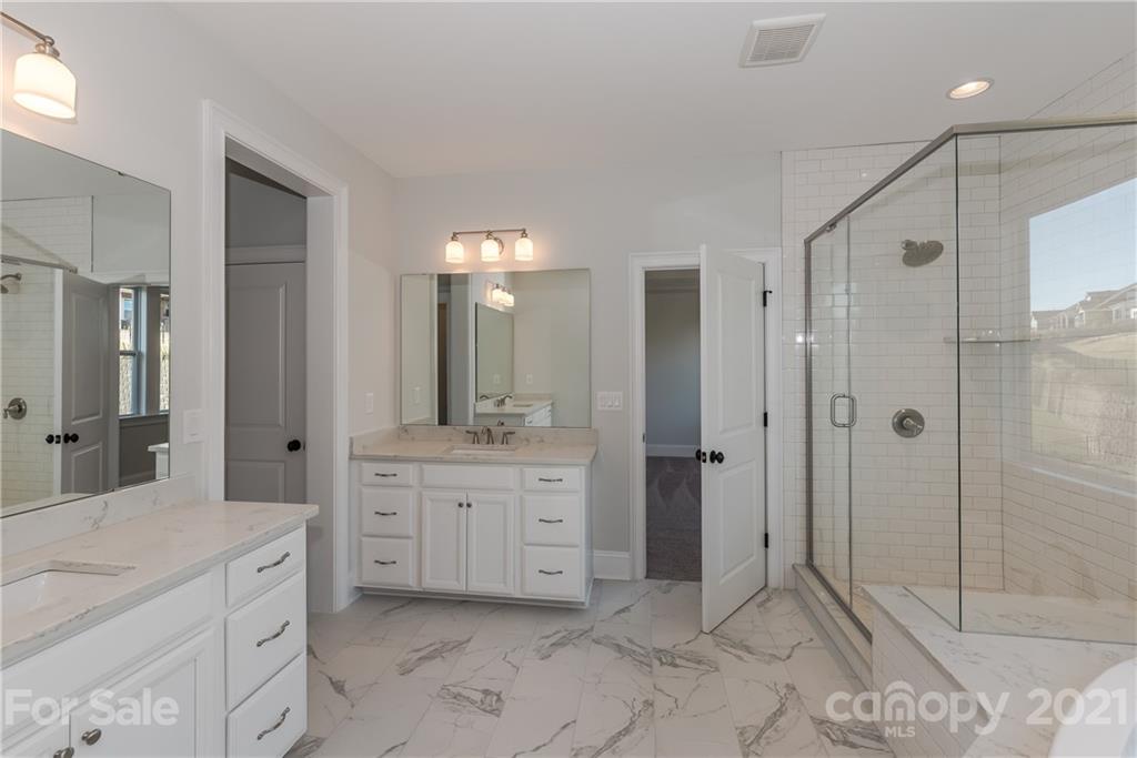 4006 Oarman Court, Unit 440 Fort Mill, SC 29708 - Photo 14 of 15 a spacious bathroom with a shower sink and mirror