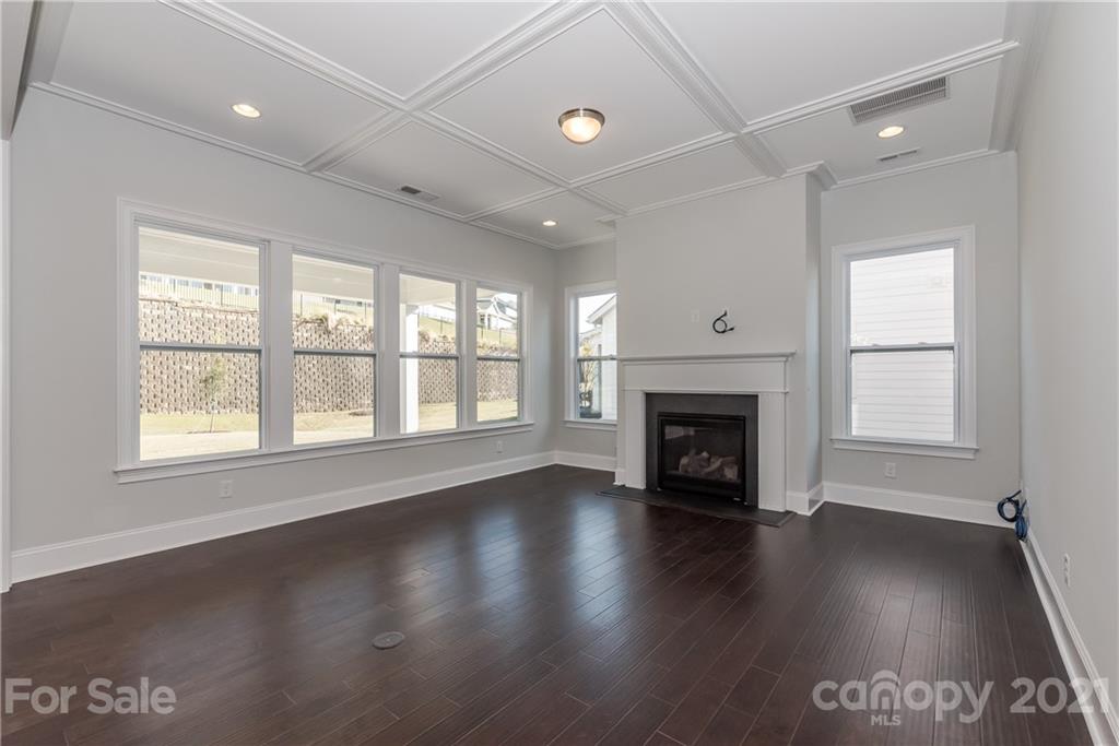 4006 Oarman Court, Unit 440 Fort Mill, SC 29708 - Photo 7 of 15 an empty room with wooden floor fireplace and windows