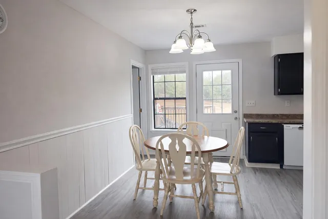 a view of a dining room with furniture and chandelier