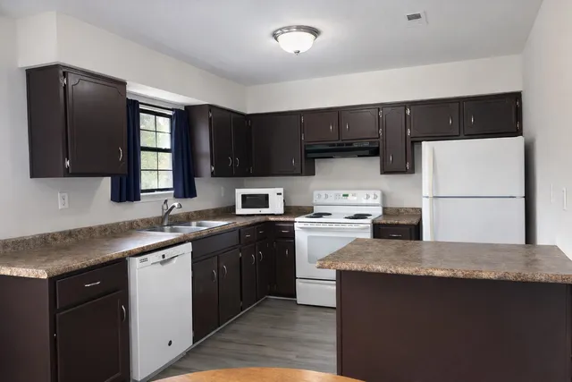 a kitchen with a sink a stove a refrigerator and cabinets