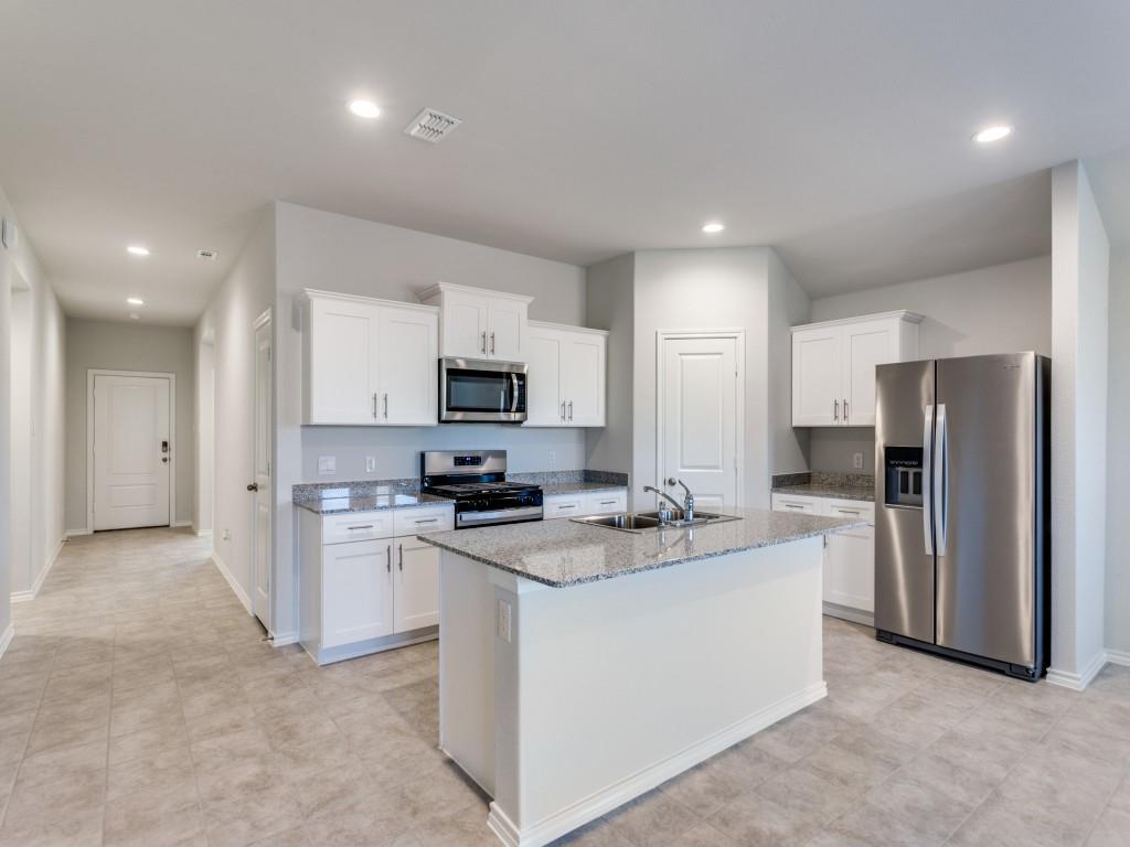 548 Bronze Circle West Springtown, TX 76082 - Photo 2 of 11 Kitchen with white cabinetry, stainless steel appliances, granite countertops, and a central island with an undermount sink