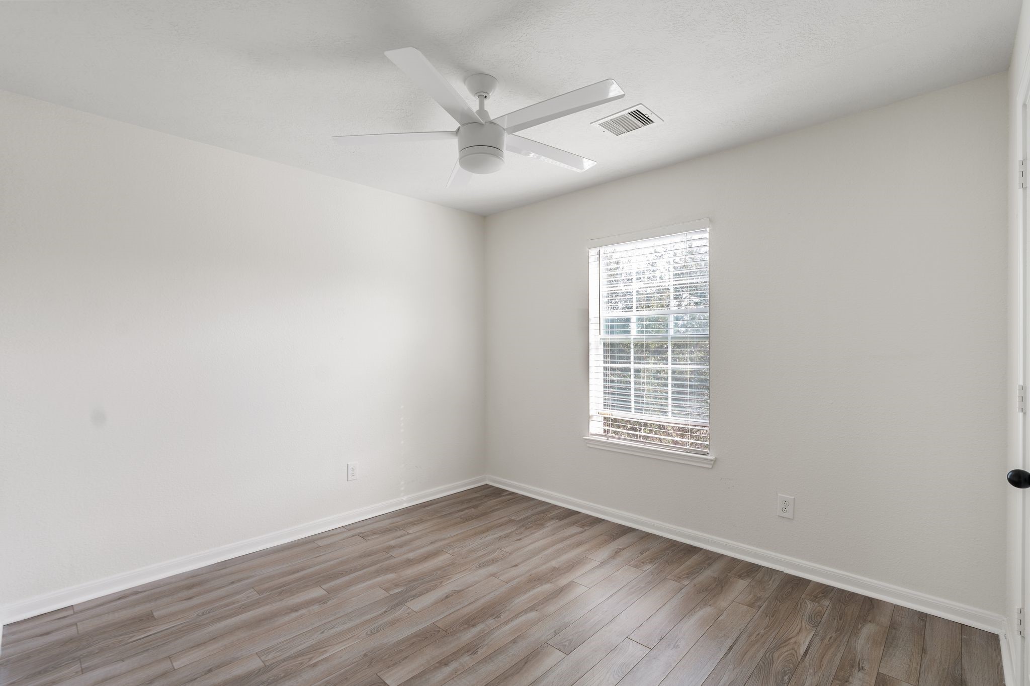 18102 Clayton Bluff Lane Cypress, TX 77433 - Photo 25 of 30 an empty room with wooden floor fan and windows