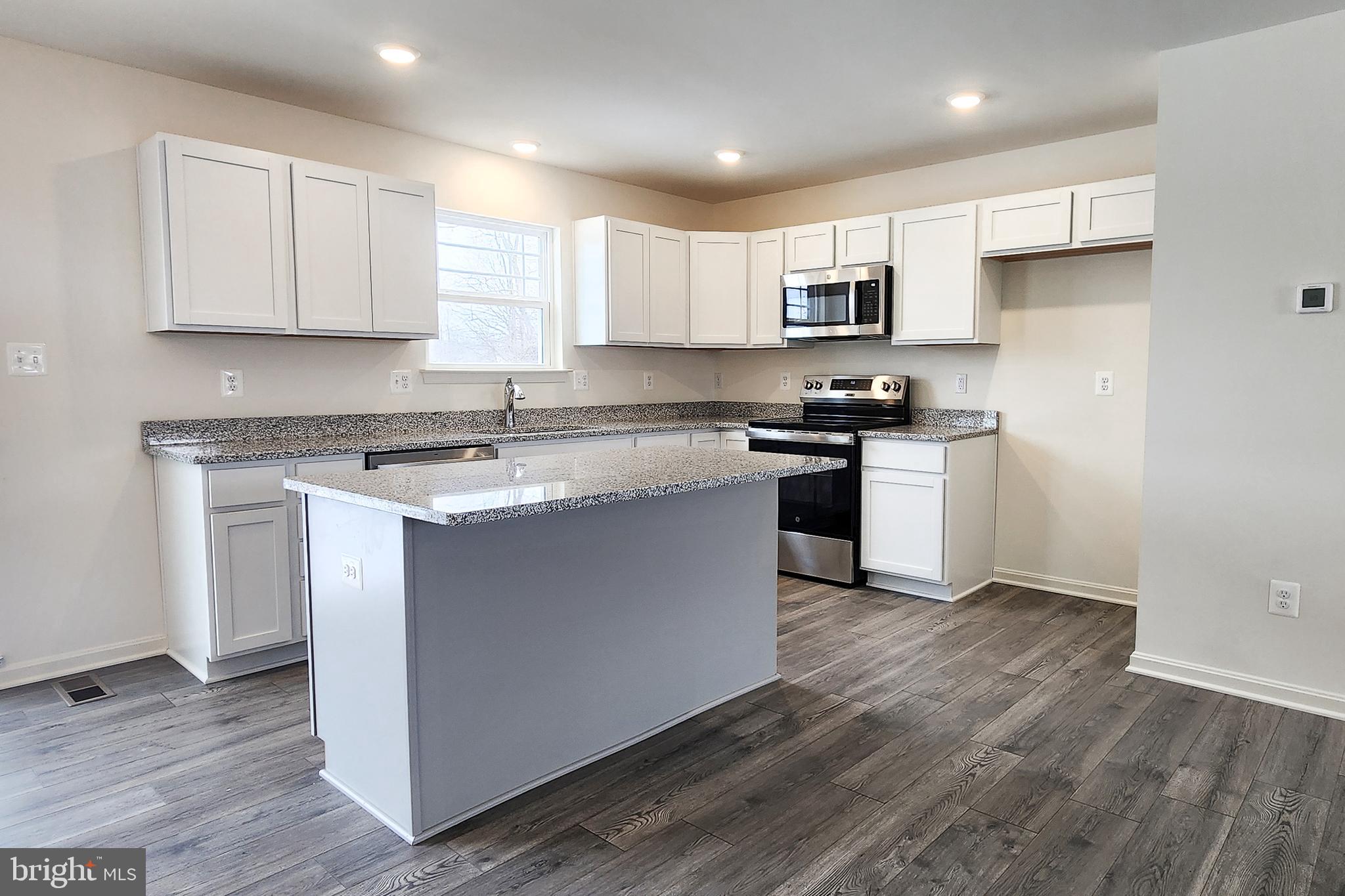 5407 Harrier Way Waynesboro, PA 17268 - Photo 21 of 35 a kitchen with stainless steel appliances granite countertop a stove top oven a sink and white cabinets with wooden floor