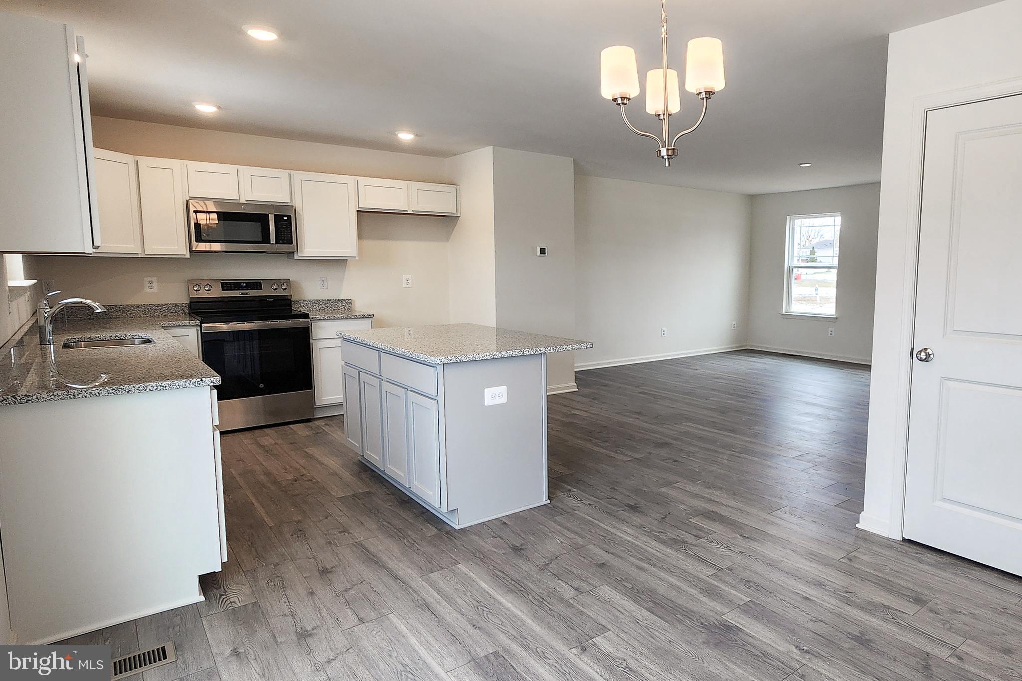 5407 Harrier Way Waynesboro, PA 17268 - Photo 23 of 35 a kitchen with stainless steel appliances granite countertop a stove top oven a sink dishwasher and a microwave oven on the wooden floor