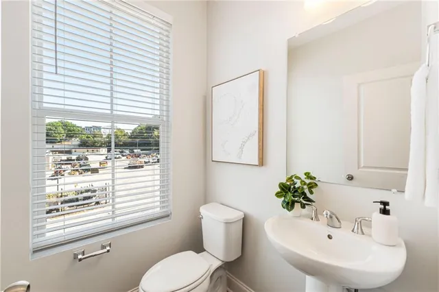 a bathroom with a sink a toilet and a window