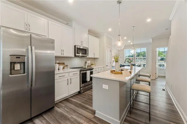 a kitchen with kitchen island a sink appliances and cabinets