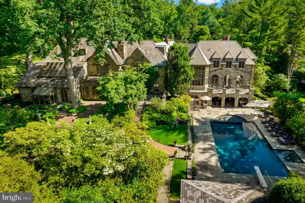 an aerial view of a house with a yard and large trees