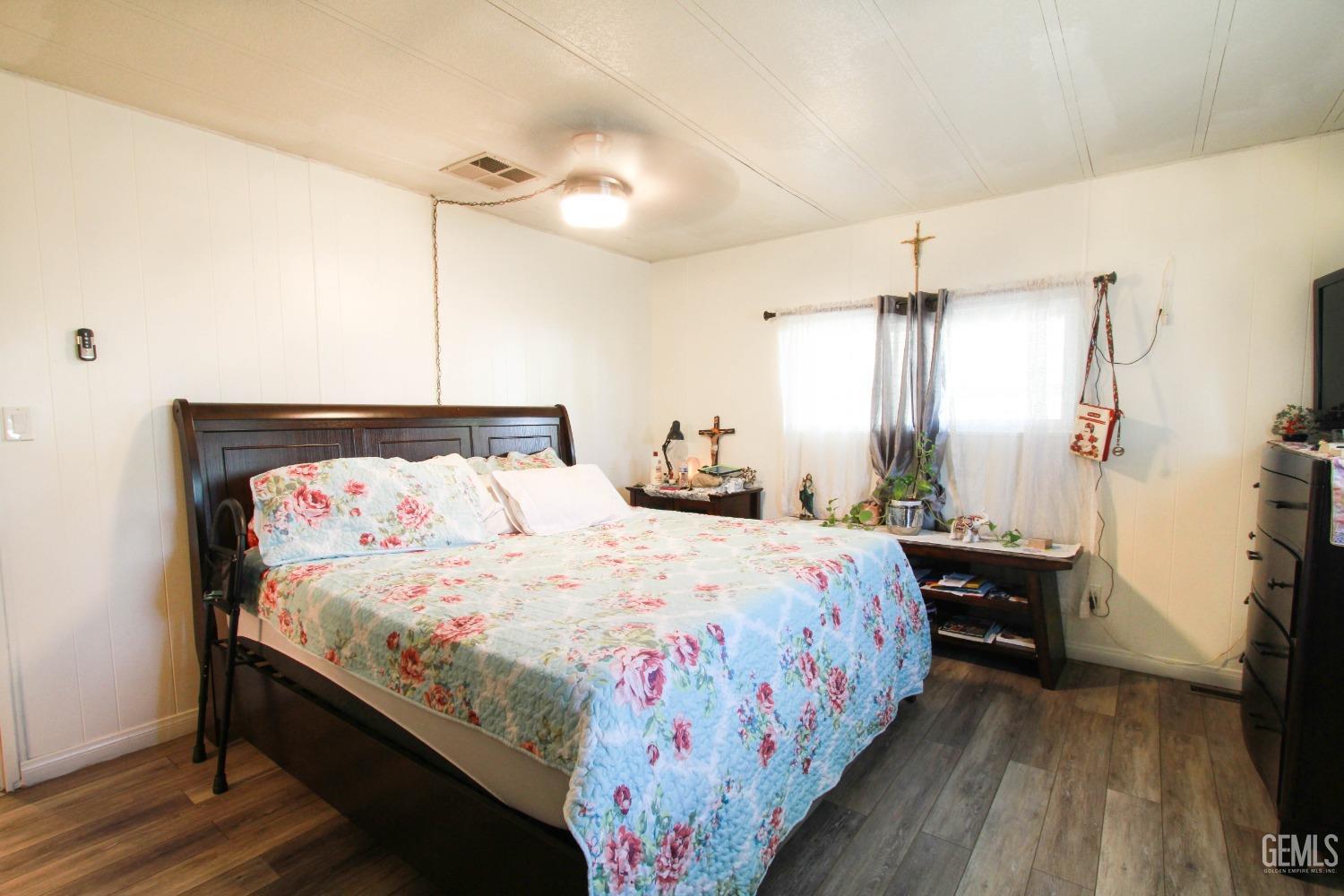 Undisclosed Address Bakersfield, CA 93304 - Photo 16 of 27 a bedroom with a bed and a chandelier