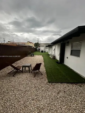 a view of a backyard with table and chairs with wooden fence