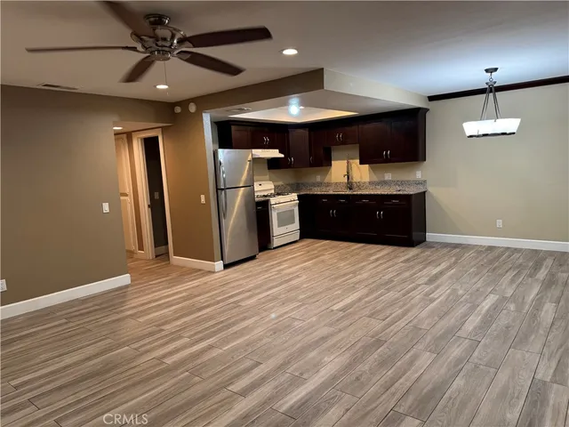 an open kitchen with a refrigerator and microwave