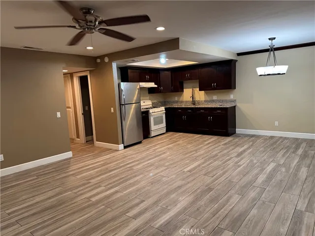 an open kitchen with a refrigerator and microwave