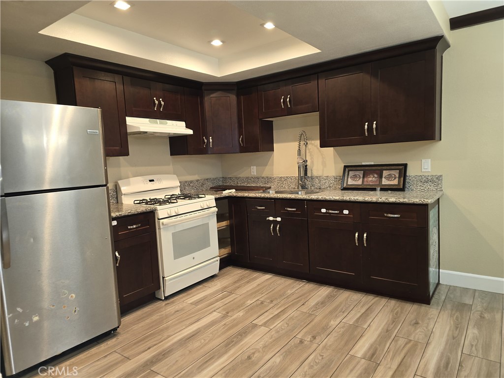 1370 Wheaton Way Riverside, CA 92507 - Photo 5 of 17 a kitchen with stainless steel appliances granite countertop a refrigerator a sink a stove and microwave