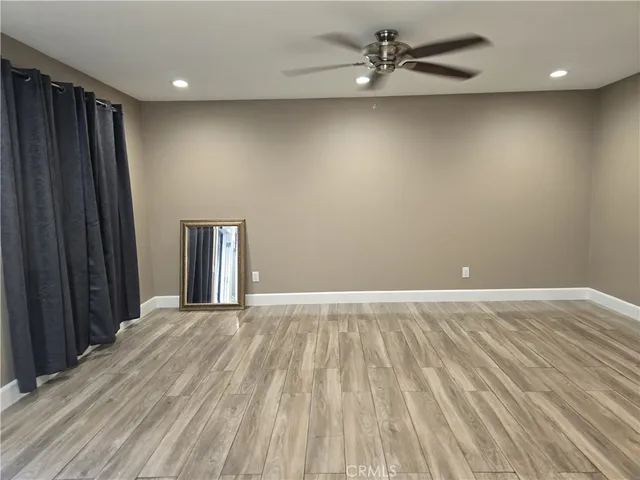 en empty room with wooden floor and windows