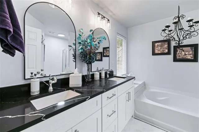 a bathroom with a granite countertop sink a mirror and a shower