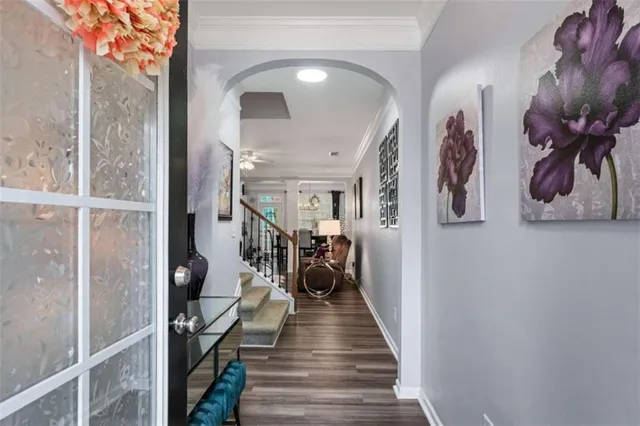 a view of a hallway with wooden floor and a large mirror