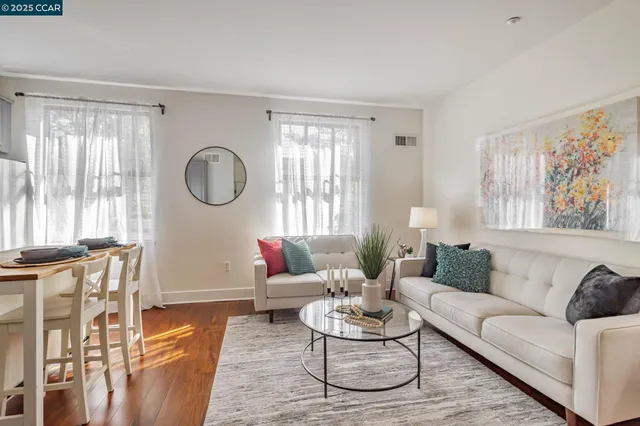 a living room with furniture a fireplace wooden floor and a large window