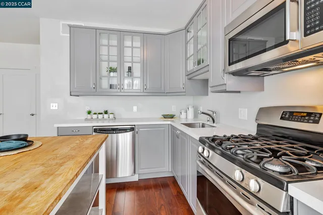 a kitchen with stainless steel appliances a sink a stove and cabinets