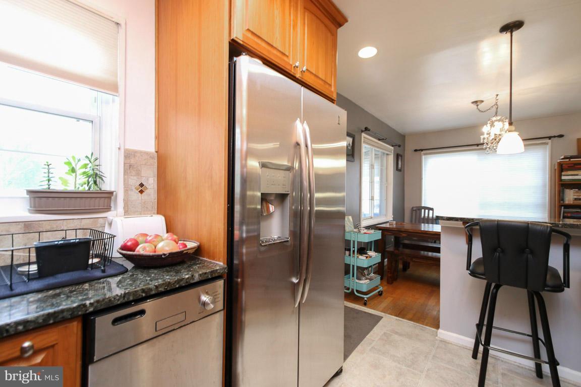 417 Kerwin Road Silver Spring, MD 20901 - Photo 11 of 30 a kitchen with granite countertop a refrigerator a stove a dining table and chairs
