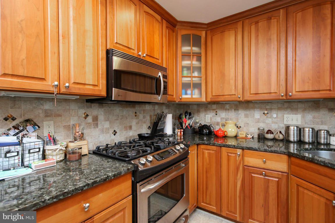 417 Kerwin Road Silver Spring, MD 20901 - Photo 12 of 30 a kitchen with stainless steel appliances granite countertop white cabinets and a stove top oven