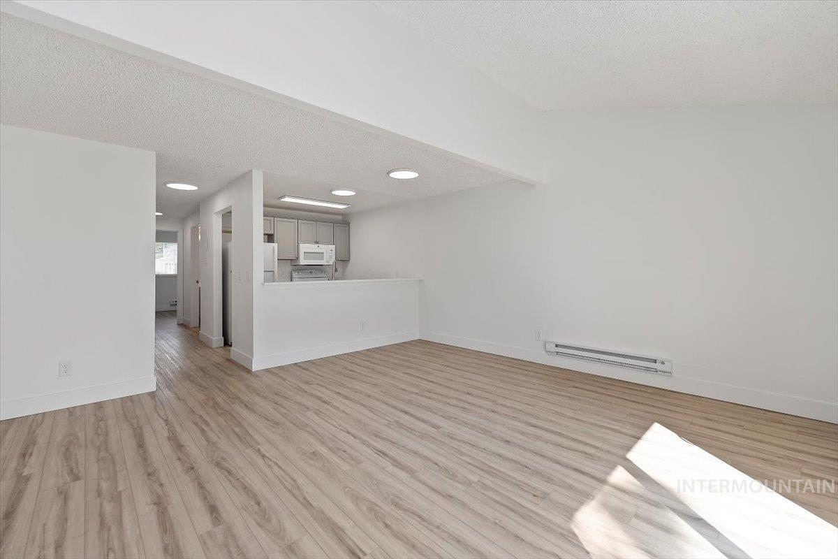259 Pheasant Road West, Unit 3 Twin Falls, ID 83301 - Photo 6 of 24 Unfurnished living room featuring light wood-type flooring, a textured ceiling, and baseboard heating