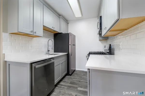 a kitchen with stainless steel appliances a sink and a refrigerator