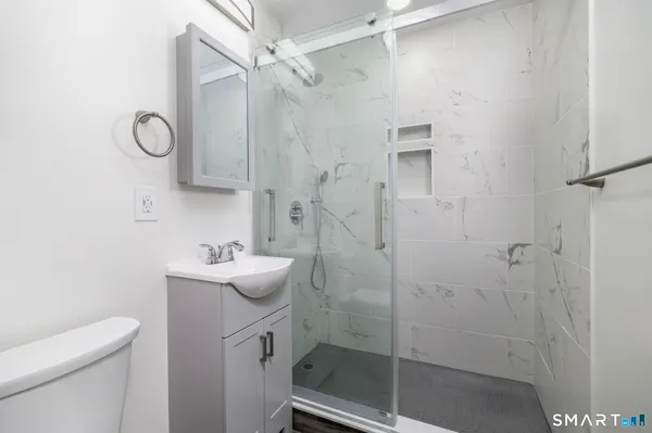 a bathroom with a sink a toilet and shower