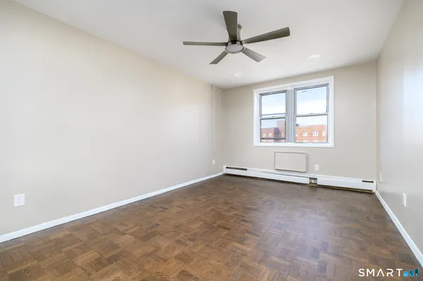 an empty room with a window and a ceiling fan