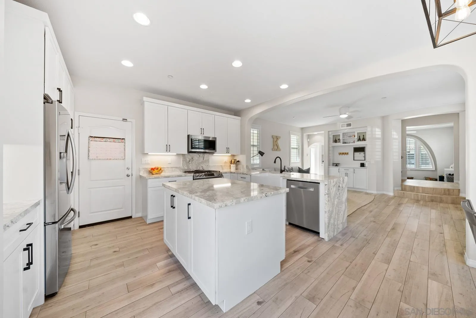 17083 Ralphs Ranch Road San Diego, CA 92127 - Photo 8 of 61 a kitchen with white cabinets and stainless steel appliances