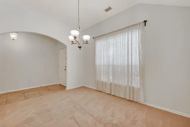 a view of a room with a hanging light and kitchen