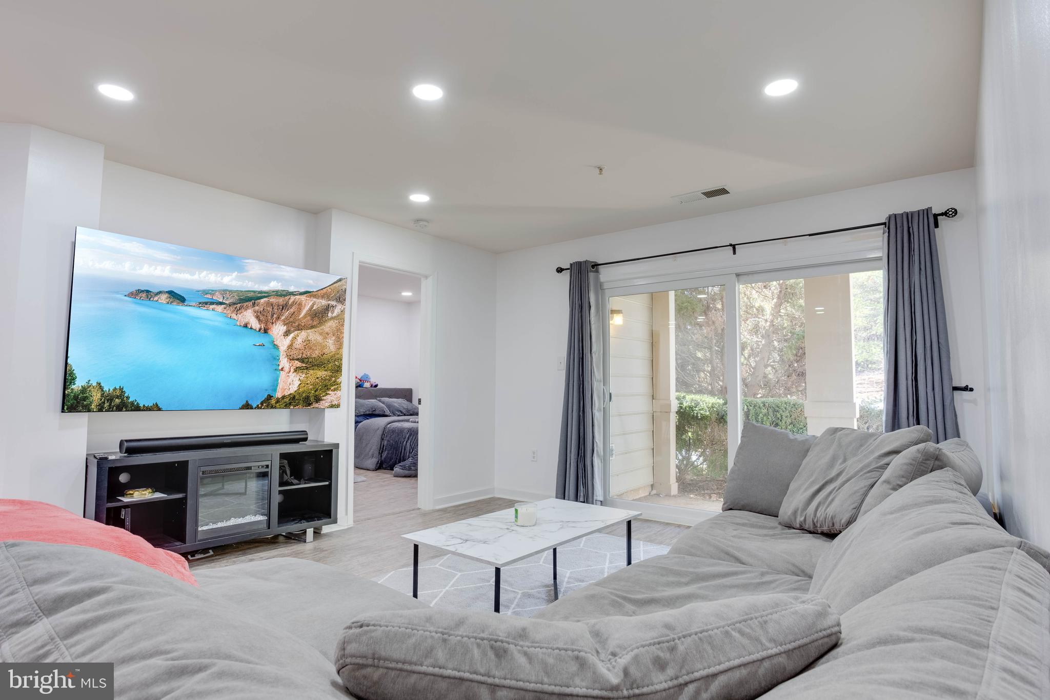 1049 Gardenview Loop, Unit 201 Woodbridge, VA 22191 - Photo 6 of 16 a living room with furniture a fireplace and a flat screen tv