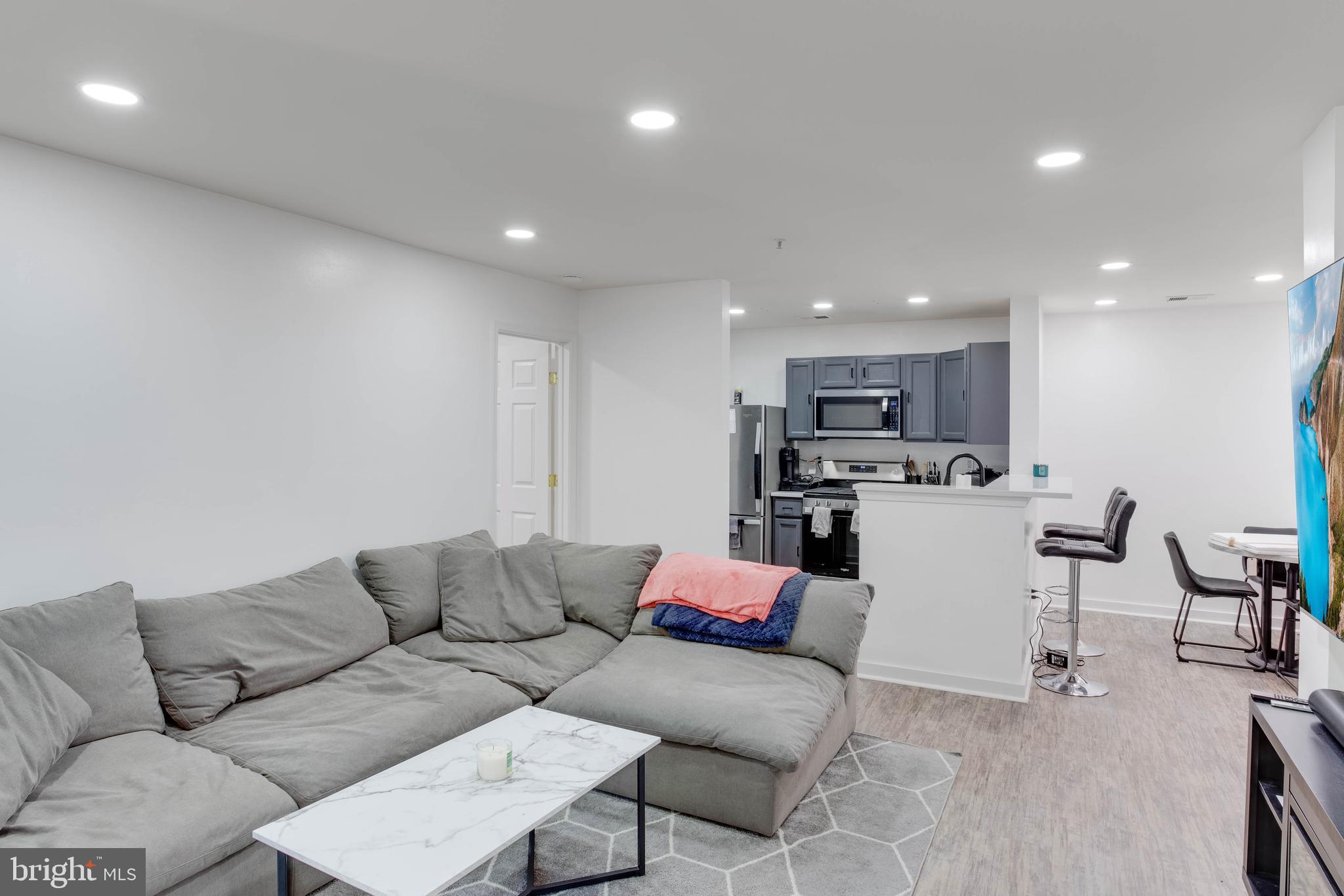 1049 Gardenview Loop, Unit 201 Woodbridge, VA 22191 - Photo 7 of 16 a living room with lots of furniture and kitchen view