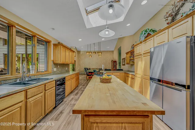 a dining room with furniture a rug a couch and a chandelier