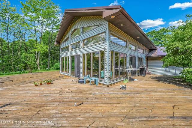 a view of a house with a big yard and large trees