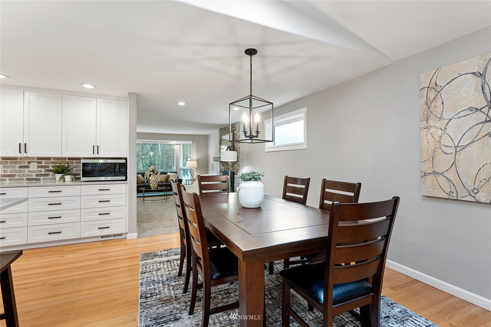 21330 2nd Avenue Southeast Bothell, WA 98021 - Photo 6 of 27 a kitchen with stainless steel appliances kitchen island granite countertop a table chairs in it and wooden floors