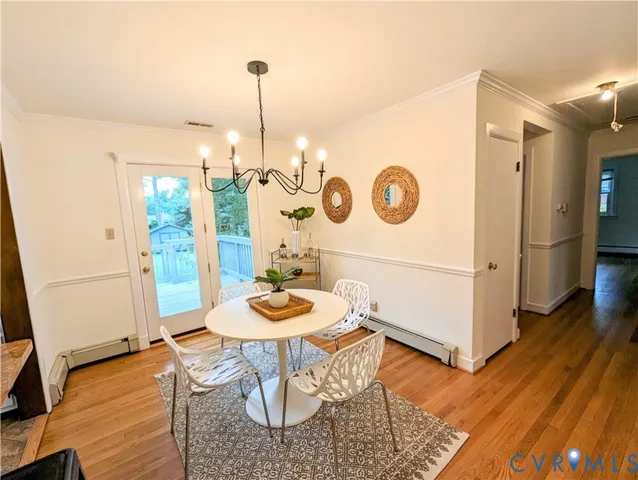 a view of a dining room with furniture wooden floor and a chandelier
