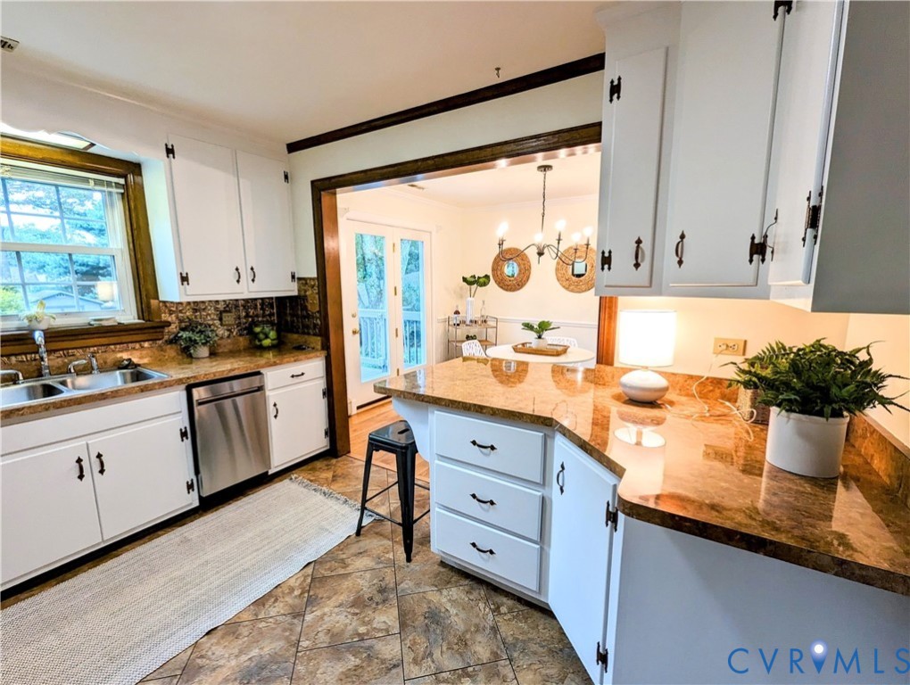 8401 Bronwood Road Henrico, VA 23229 - Photo 6 of 11 a kitchen with granite countertop a stove a sink and white cabinets with wooden floor