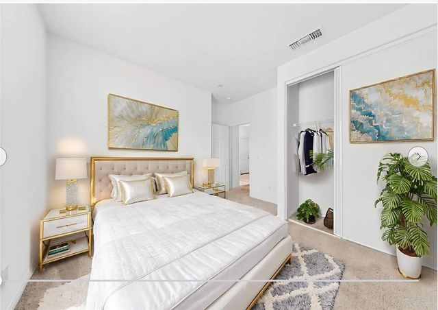 a bedroom with a bed and a painting on the wall