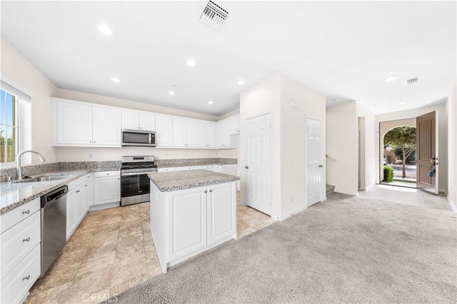 a kitchen with granite countertop a sink and white stainless steel appliances