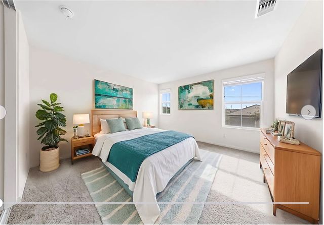 a bedroom with a bed and a potted plant